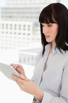 A woman looking at the screen of her tablet pc while in her office