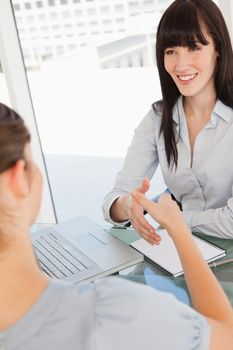 Both women get ready to shake hands by moving their hands closer together