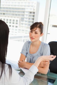 A black haired employee chats to her brunette co-worker