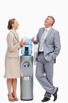 People in suit laughing next to the water dispenser against white background