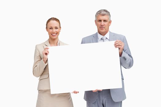 Business people holding a poster against white background
