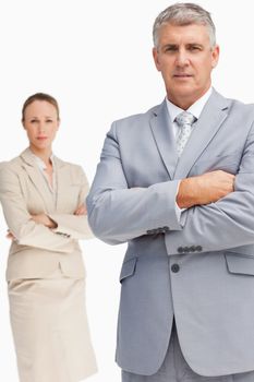 Serious business people standing with folded arms against white background