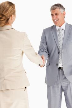 Happy business people shaking hands against white background