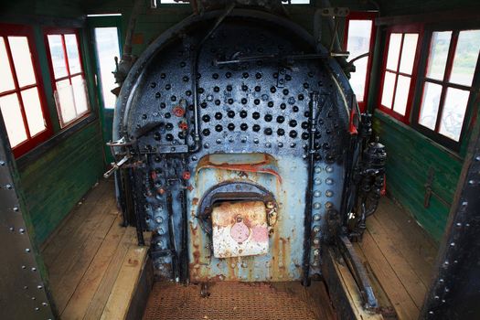 Old train engine steam boiler that is old, worn down, and rusted.