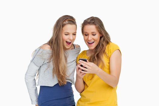 Two voiceless young women looking a smartphone against white background