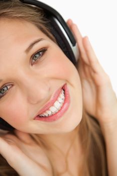 Close-up of a beauty listening to music against white background