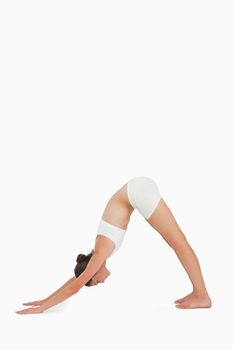 Woman doing yoga against white background