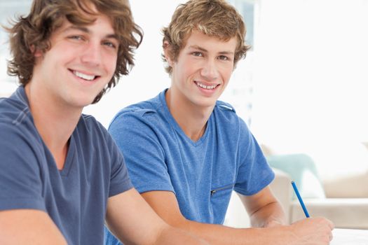 A pair of students smiling as they both look into the camera 