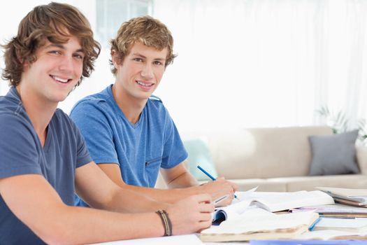 A side view shot of two smiling students as they both look into the camera 