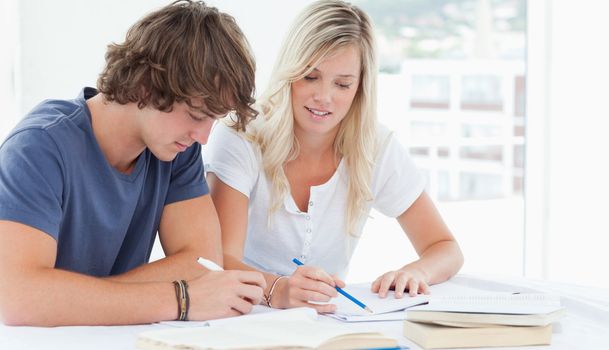 A couple of students studying together while sitting at the table