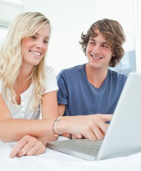 A close up of a man looking at a woman while she points at the screen 