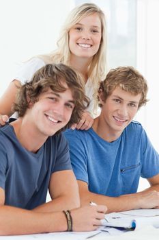 A group of smiling students at the table as they look at the camera 