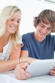 A close up shot of a smiling couple using a tablet  