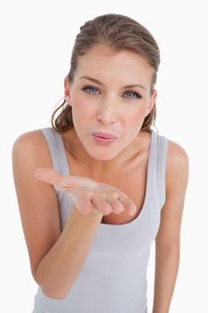 Portrait of a happy woman blowing a kiss against a white background