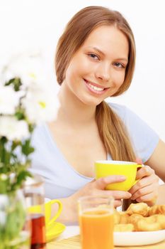 Beautiful young woman drinking tea from yellow cup