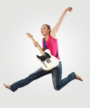 young woman playing on electro guitar and jumping