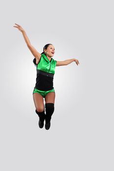 Young female dancer jumping against white background