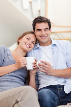 Portrait of a couple drinking coffee in their living room