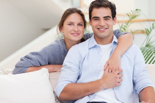 Happy couple hugging while looking at the camera