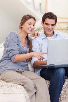 Portrait of a couple using a laptop in their living room