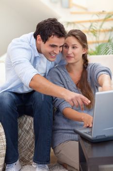 Portrait of a surprised couple using a laptop in their living room