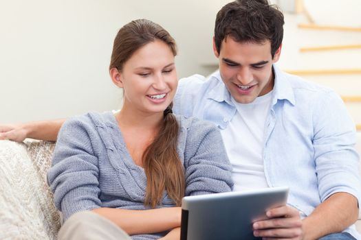 Young couple using a tablet computer in their living room