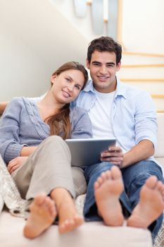 Portrait of a young couple using a tablet computer in their living room