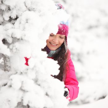 winter girl behind snow tree 