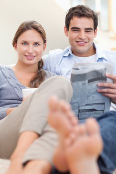 Portrait of a couple reading a newspaper in the morning in their living room