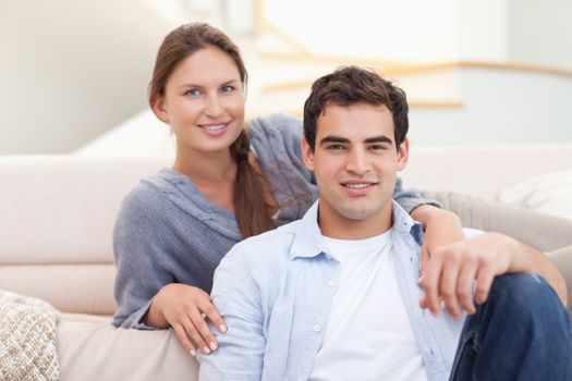 Couple sitting in their living room while looking at the camera