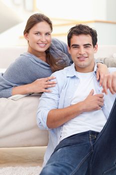 Delighted couple hugging in their living room