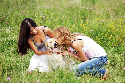 girlfriends and dog in green grass field