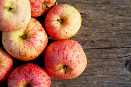 Top view of ripe red apples on a wooden plank