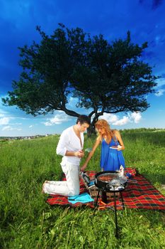 man and woman on picnic in green grass