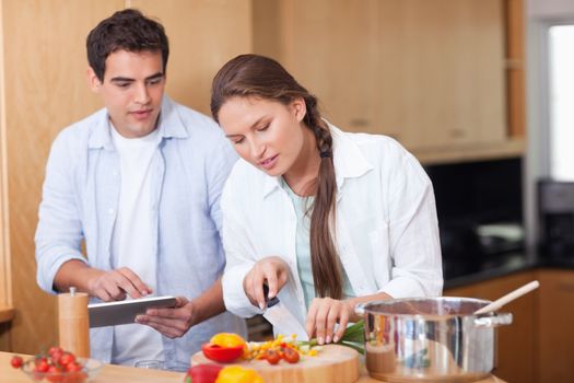 Modern couple using a tablet computer to cook in their kitchen