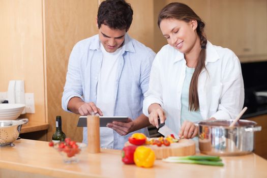 Couple using a tablet computer to cook in their kitchen