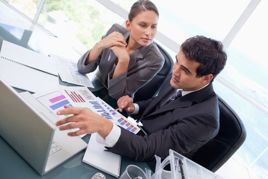 Business team studying statistics with a laptop in an office