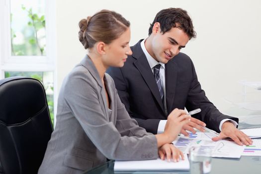 Smiling business team studying statistics in a meeting room