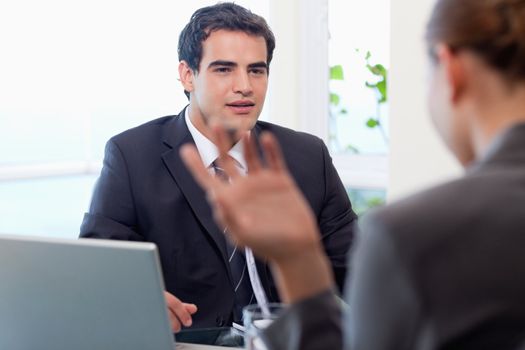Handsome manager interviewing a female applicant in his office