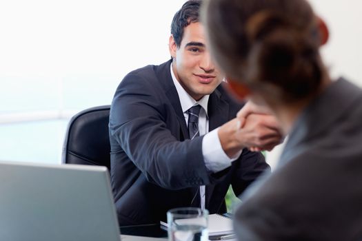 Satisfied manager interviewing a female applicant in his office