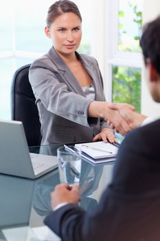 Young businesswoman welcomes customer in her office