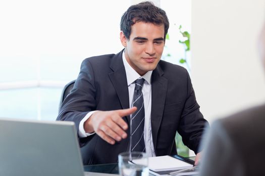 Businessman giving his hand in his office