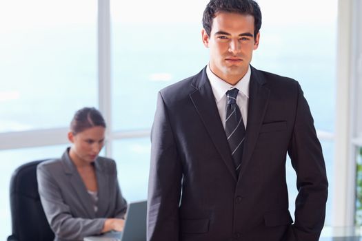 Young businessman with his secretary behind him