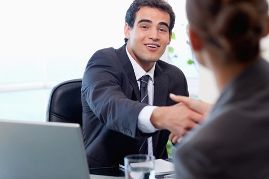 Smiling manager interviewing a female applicant in his office