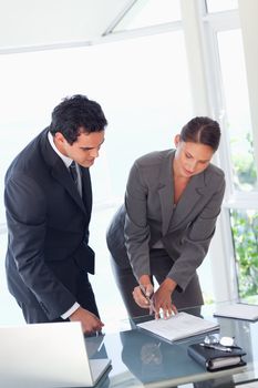 Young businesswoman showing partner where to sign