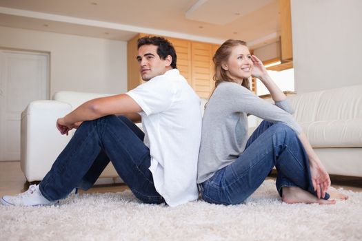 Side view of young couple sitting back-to-back