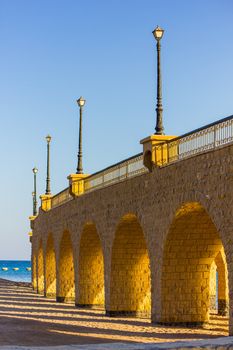 The arched stone colonnade with suspended lanterns