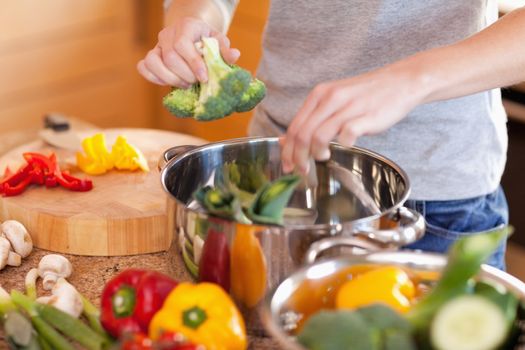 Young woman preparing vegetable soup