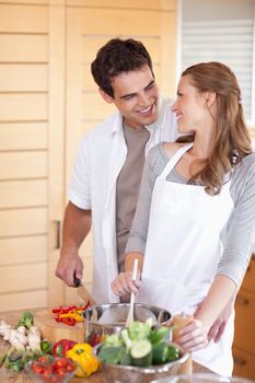 Young man helping his girlfriend cooking