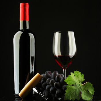 bottle with red wine and glass and grapes